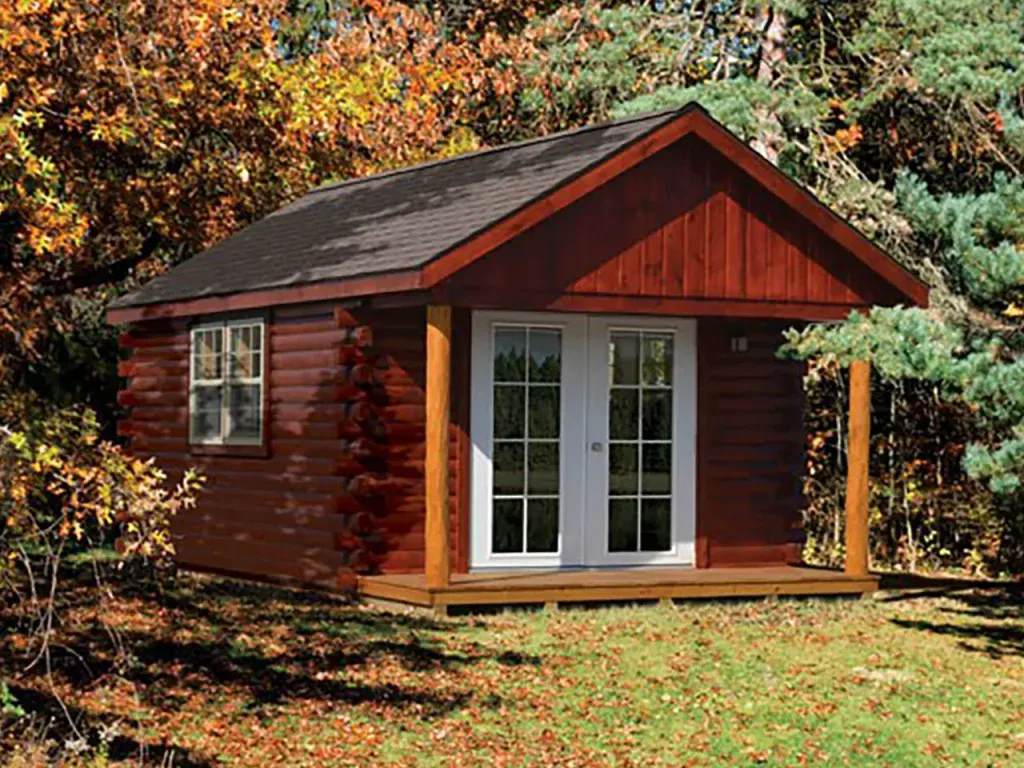 Red log cabin style shed with a covered front porch and glass double doors